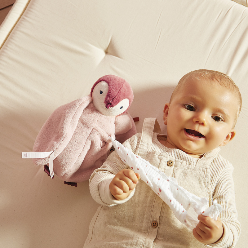 Bebê brincando com pinguim Complices rosa