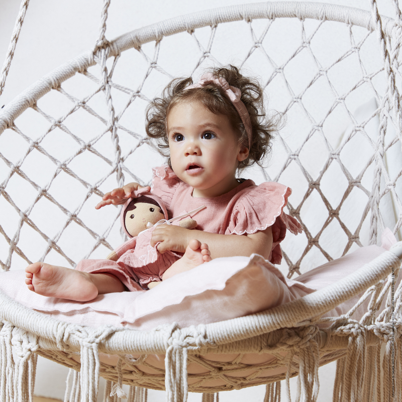 Menina abraçando boneca Tendresse rosa